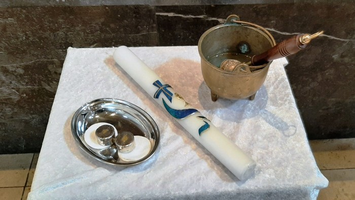 Auf dem Tisch stehen eine Schale, ein weißes Objekt und ein Metallgefäß.