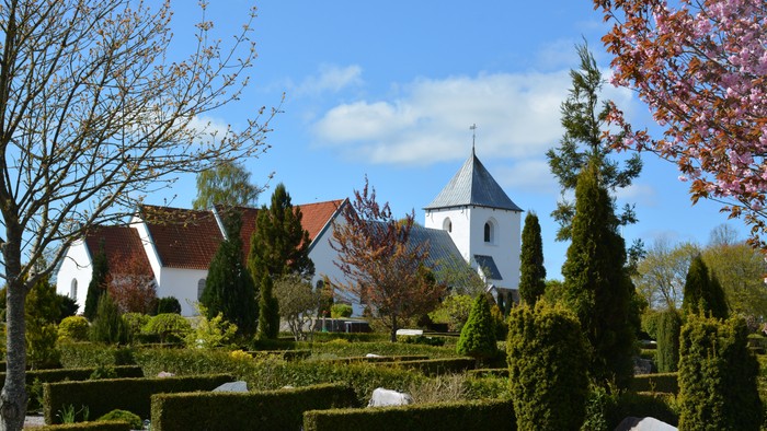 En smuk kirke med have og træer