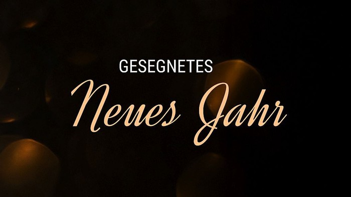 Das Bild zeigt einen festlichen Gruß mit dem Text „Geschenkes Neues Jahr“ auf einem dunklen Hintergrund mit verschwommenen Lichtern.