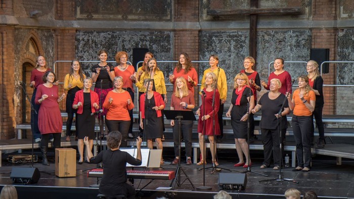 Ein Chor singt auf einer Bühne vor einem Publikum