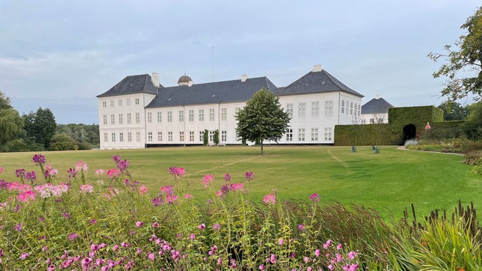 Stor hvid kastedal med blomster og græsplæne