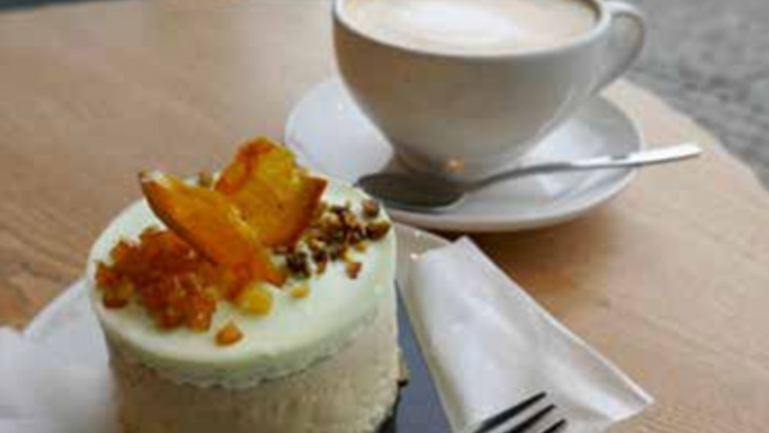 Ein Stück Kuchen mit einer Tasse Kaffee auf einem Holztisch