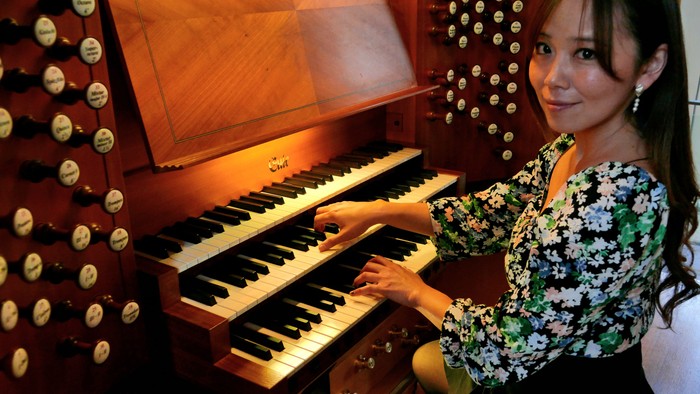 Junges Mädchen spielt auf einem Orgel.