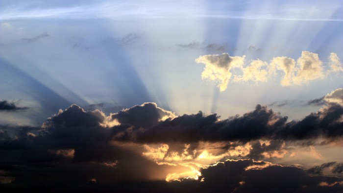 Skyen er fyldt med skyer og sollys.