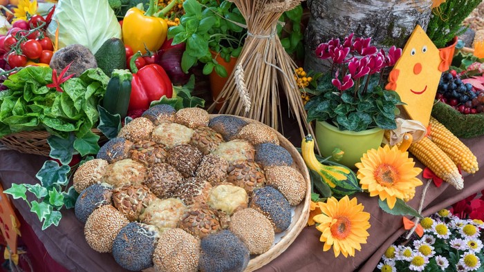 Bunter Obst- und Gemüsestand mit Broten und Blumen