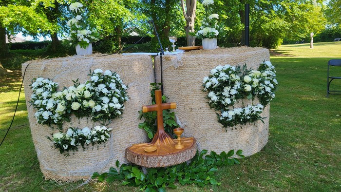 En hage med blomsterarrangementer og en korsformet fontæne.