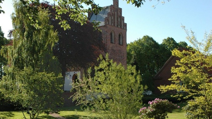 En rolig park med en lille sø og et historisk tårn i baggrunden