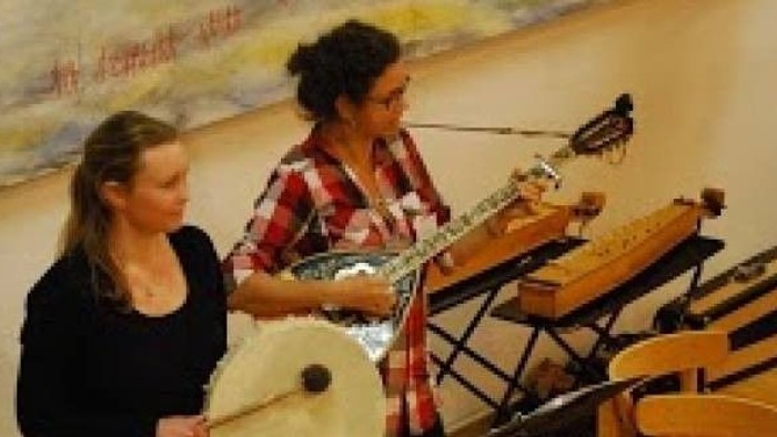 To kvinder spiller musikinstrumenter på scenen