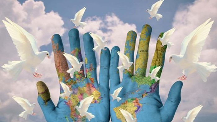 Zwei Hände halten die Erde, umgeben von fliegenden Tauben am Himmel