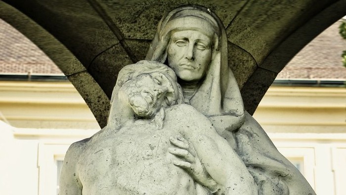 Die Statue zeigt eine Frau, die einen nackten Mann hält.