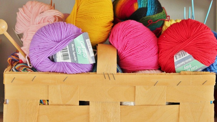 En kiste med forskellige farver af garn og strå.