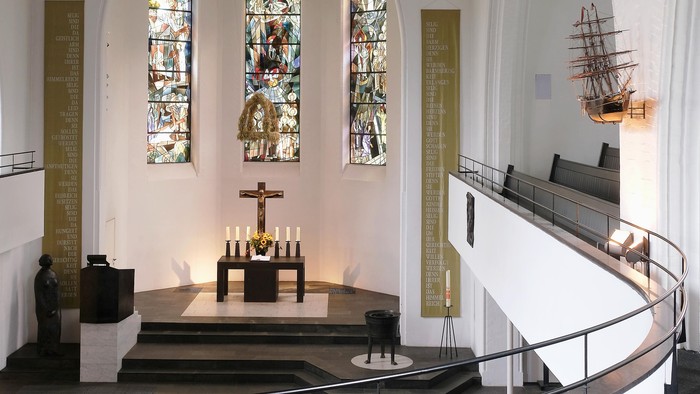 Die Kirche hat ein hohes Gewölbe, bunte Fenster und eine Schiffsmodell-Ausstellung.