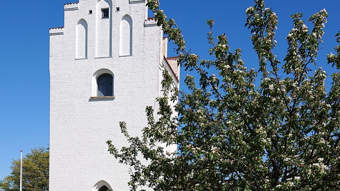 Et hvidt tårn med smukke arkitektoniske detaljer i en parkagtig omgivelse