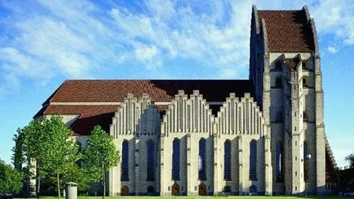 Gammel kirke med høje tårne og store vinduer.