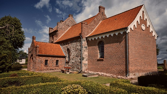 Det gamle stenhus med røde tag og mursten.