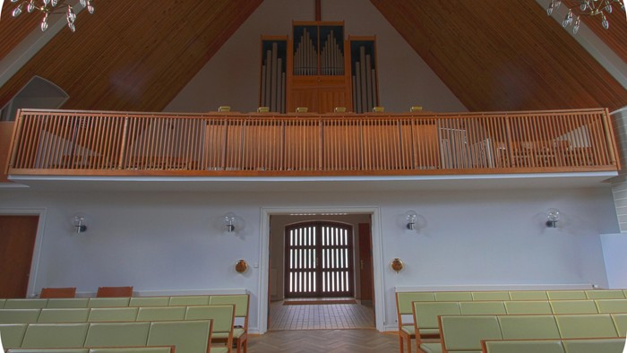 Indenrigs syn på kirke med orgel og alter.