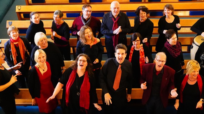 Ein Chor singt fröhlich in einem Saal