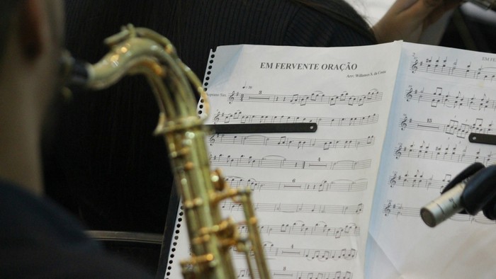 En saksofonist spiller og ser på noter