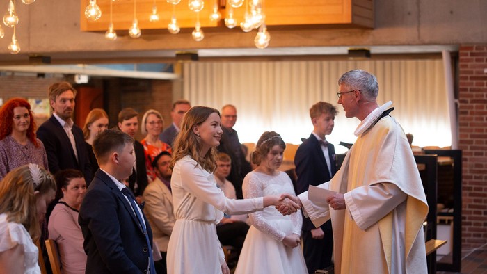 En præst udfører en ceremoni for et par i en kirke.