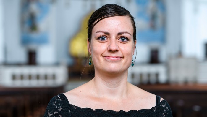 En kvinde med sort hår og svart top.