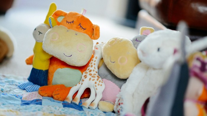 En samling legetøj på et bord, inklusiv et giraf, en hund og en kat.