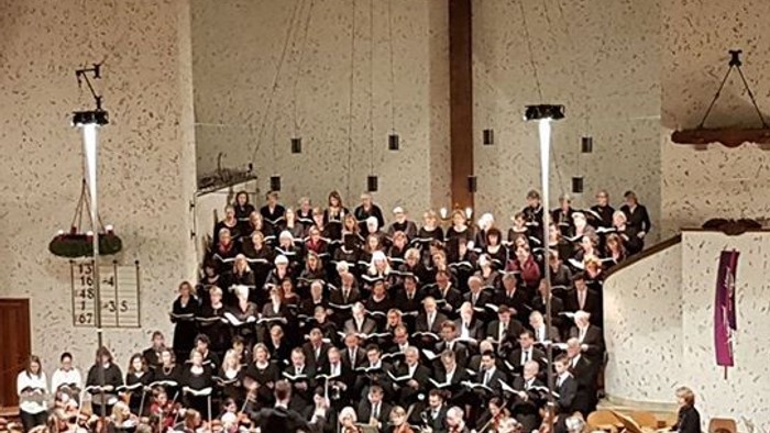 Große Kirchenchor singt unter Kreuz und Kronleuchtern