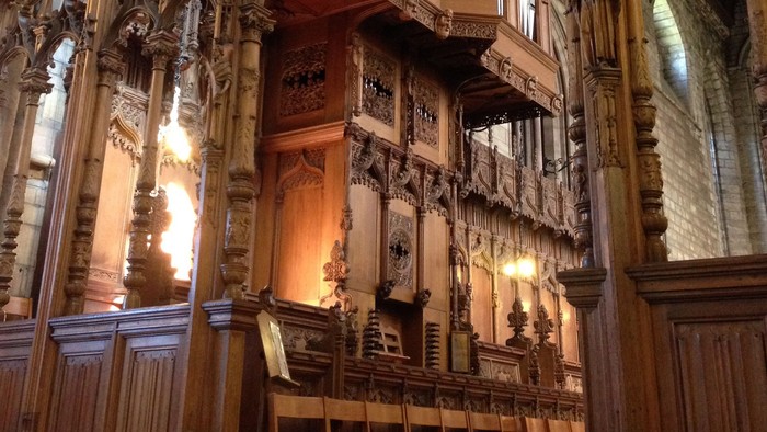 Large wooden organ inside a grand cathedral.