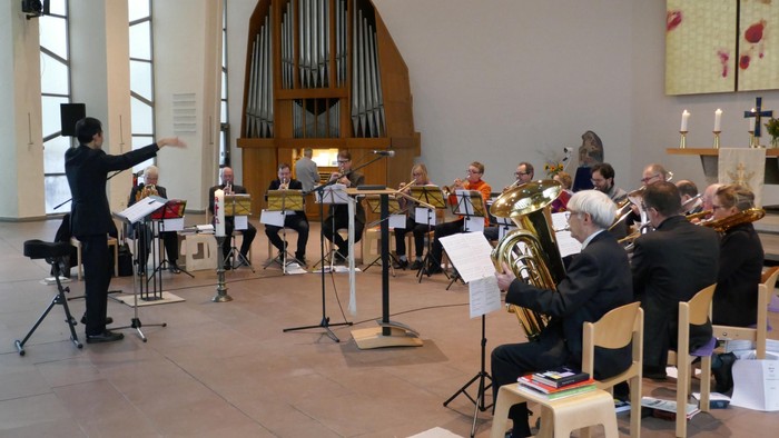Ein Orchester probt in einer Kirche unter der Leitung eines Dirigenten