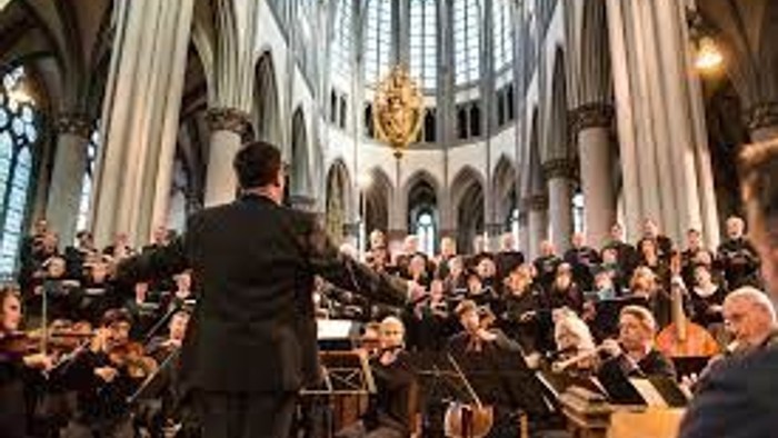 Ein Dirigent leitet ein Orchester in einer großen Kathedrale.