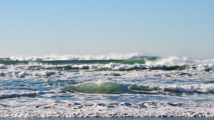 Større bølger på havet under klar himmel
