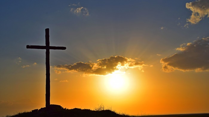 Cross silhouette against sunset sky