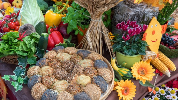 Bunter Obst- und Gemüsestand mit Broten und Blumen
