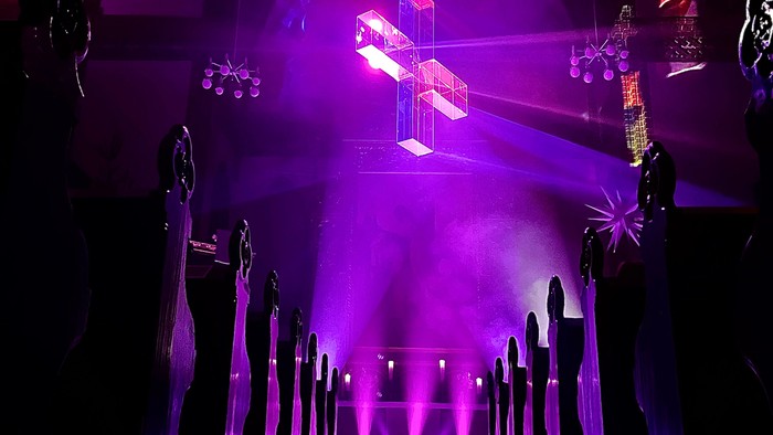 Dunkelheit und violette Beleuchtung in einer Kirche, Kreuz im Scheinwerferlicht