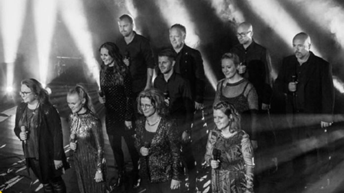 En gruppe af mennesker poser til et foto på en scene