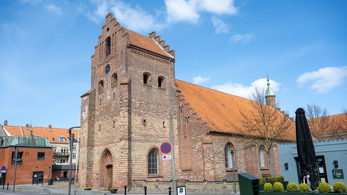 Gamle kirke med teglmur og spistegning i bymiljø