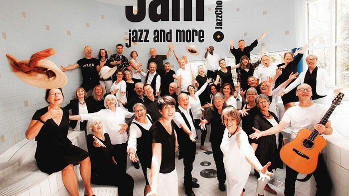 Eine Gruppe von Frauen feiert in einem Badezimmer, eine hält eine Gitarre