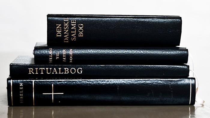 Tre sorte boger med guldindtryk og kors på dækkerne.