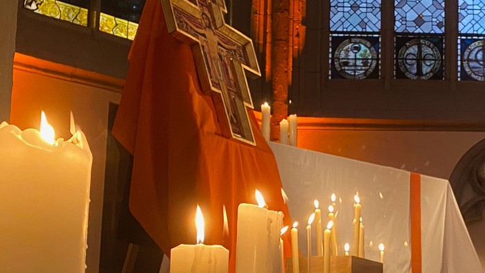 Kirchliche Innenansicht mit brennenden Kerzen und Kreuz