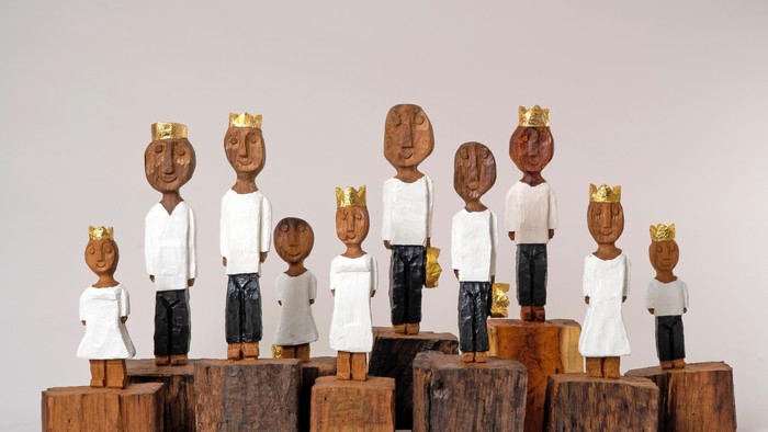 Holzskulpturen von Königen und Königinnen in weißen Roben auf Sockeln