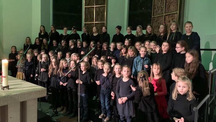 Eine Gruppe von Kindern und Erwachsenen posiert für ein Foto in einer Kirche.