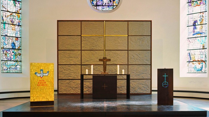 Der Altar in einer Kirche mit bunten Glasfenstern und Kerzen
