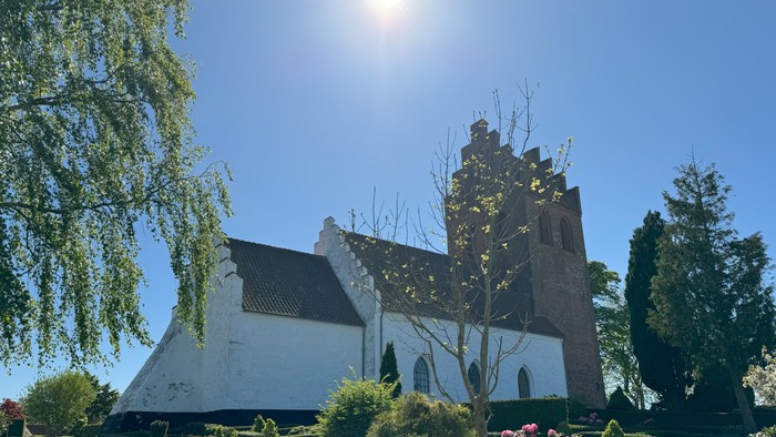 En smuk kirke med en have og træer