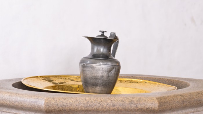 En smedekrus og en lille kanner på en fontæne