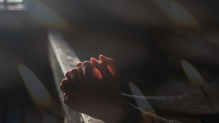 Die Hände einer Person, die ein Messer halten, umgeben von anderen Messern.