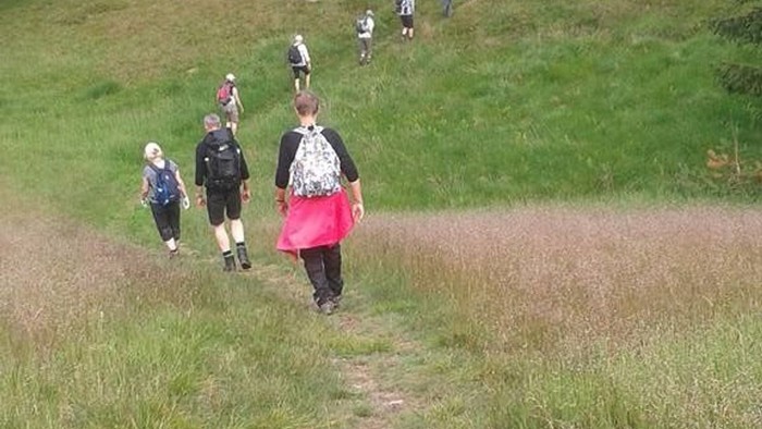 En gruppe børn går i en grøn dal.