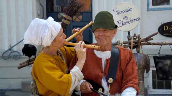 To old folkespillere med kostumer og musikinstrumenter