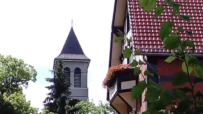 Ein hübsches Haus mit Blumenkästen und eine Kirche im Hintergrund