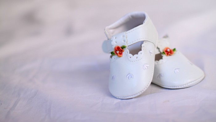 To børneskø og et par blomster på.