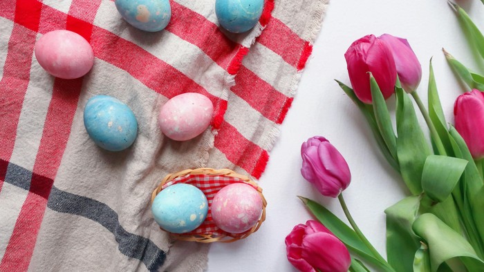 Farvede Ostereier og tulipaner på rødt og hvitt tæppe