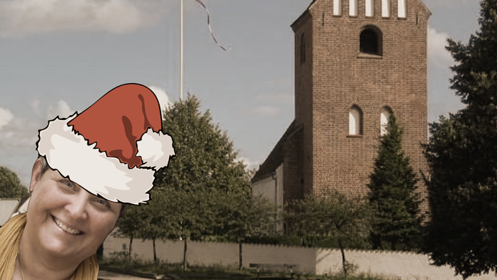 En kvinde med julehat foran kirke.
